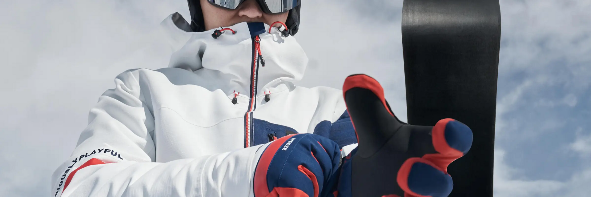 Mężczyzna zakładający rękawice na snowboard na stoku