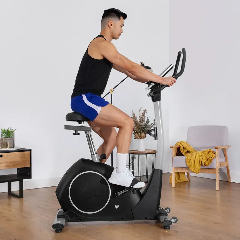 Mężczyzna w odzieży sportowej ćwiczący na rowerze stacjonarym