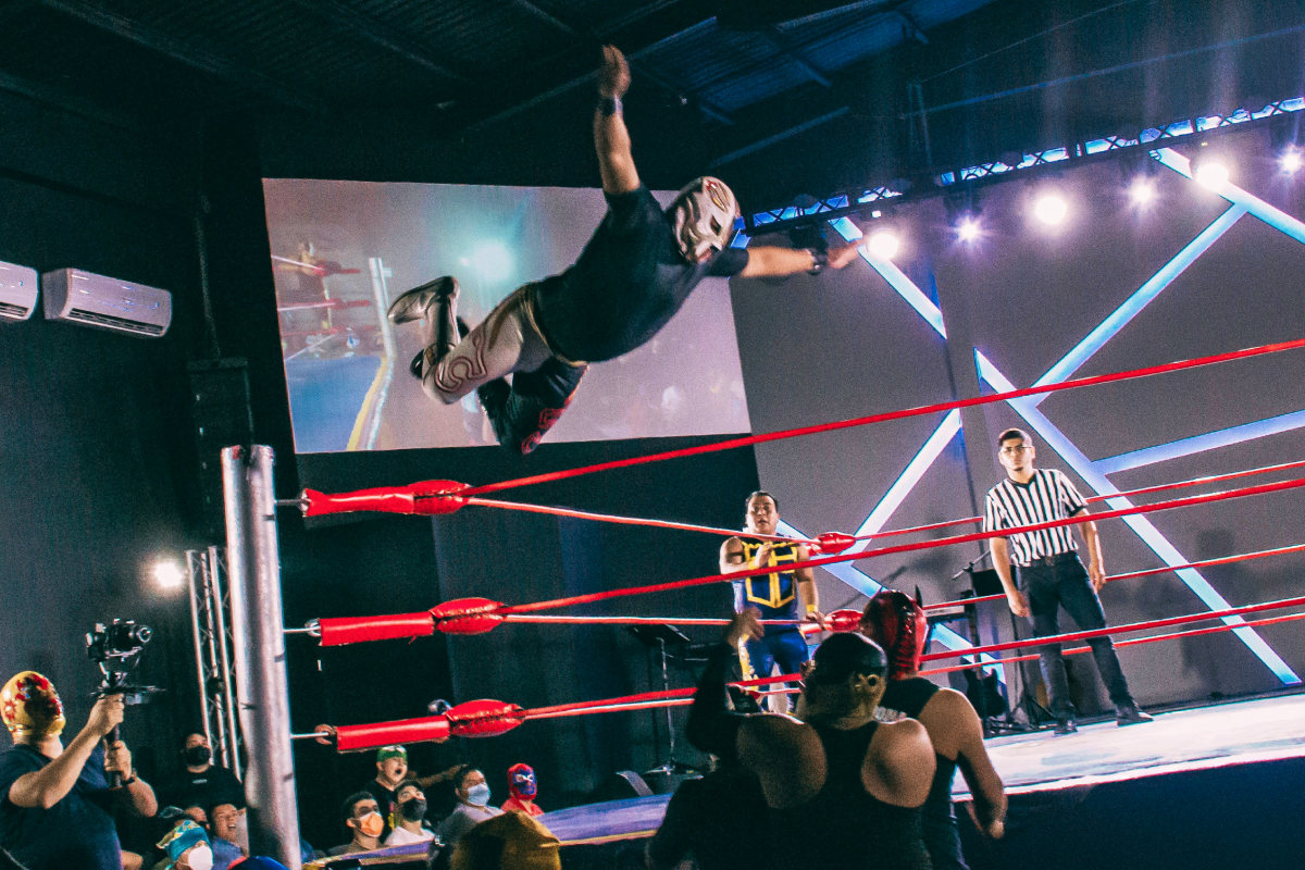 Mężczyzna w masce lecący w powietrzu podczas pokazu wrestlingu
