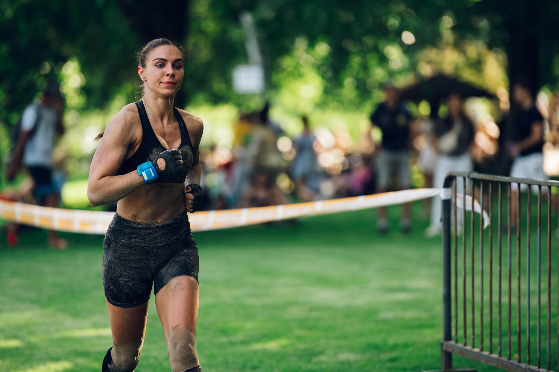 Kobieta w stroju sportowym ubrudzona błotem biorąca udział w biegu rzeźnika