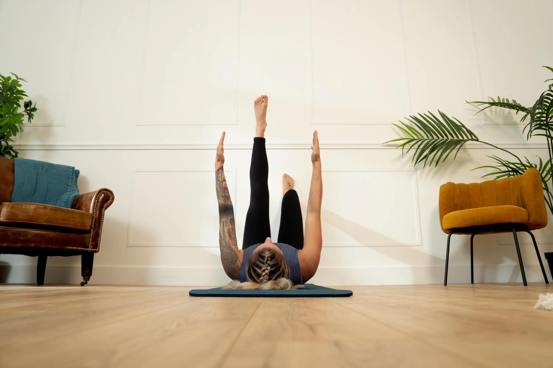 Kobieta w odzieży sportowej ćwicząca pilates przy ścianie
