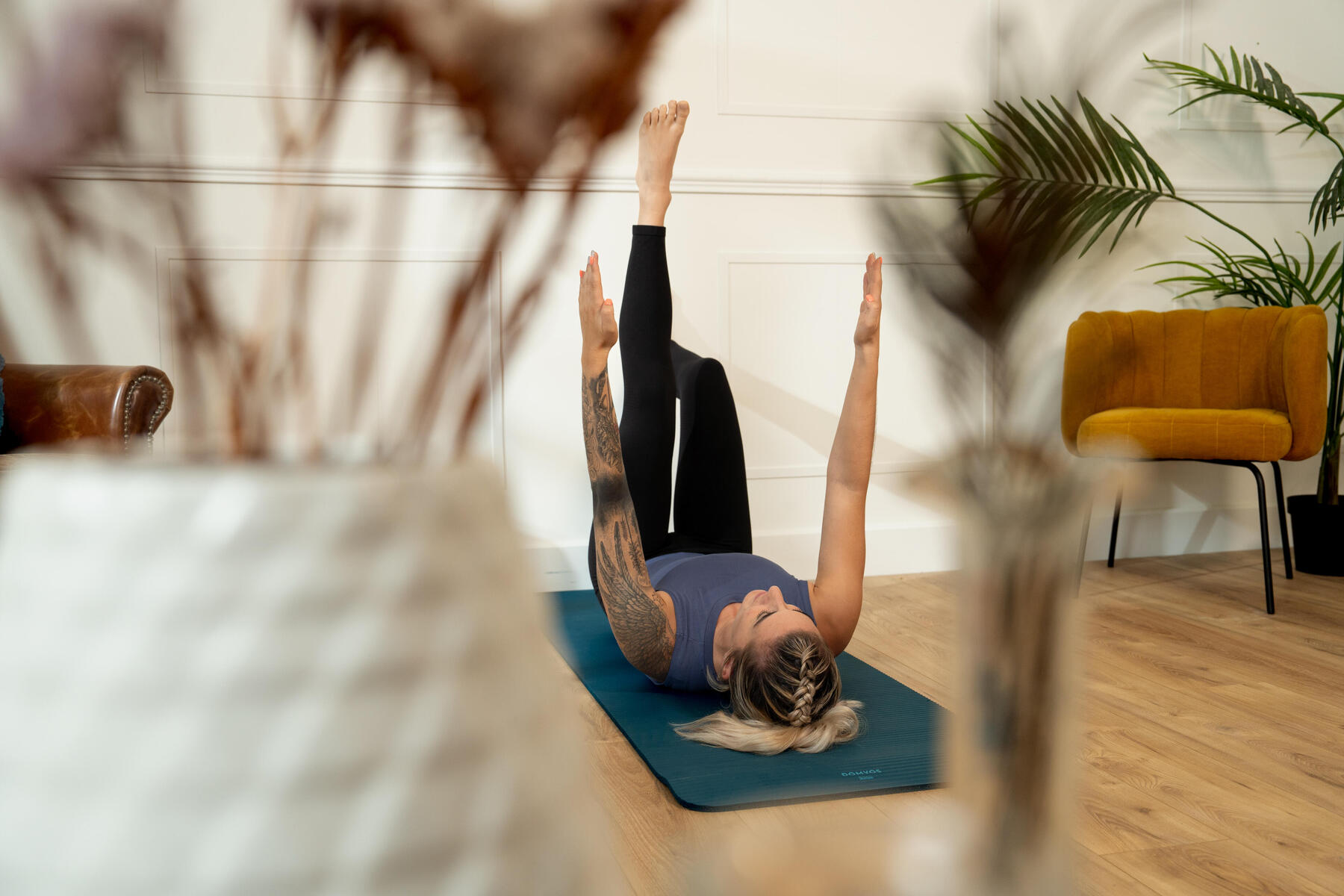 Kobieta ćwicząca na macie pilates przy ścianie
