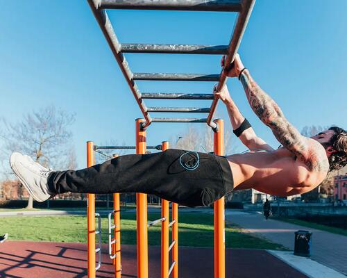 Mężczyzna wykonujący front lever na drabinkach