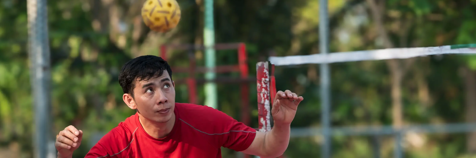 Chłopak odbijający piłkę głową grający w sepak takraw
