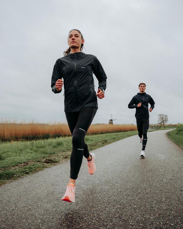 Kobieta i mężczyzna w odzieży sportowej biegający po asfalcie