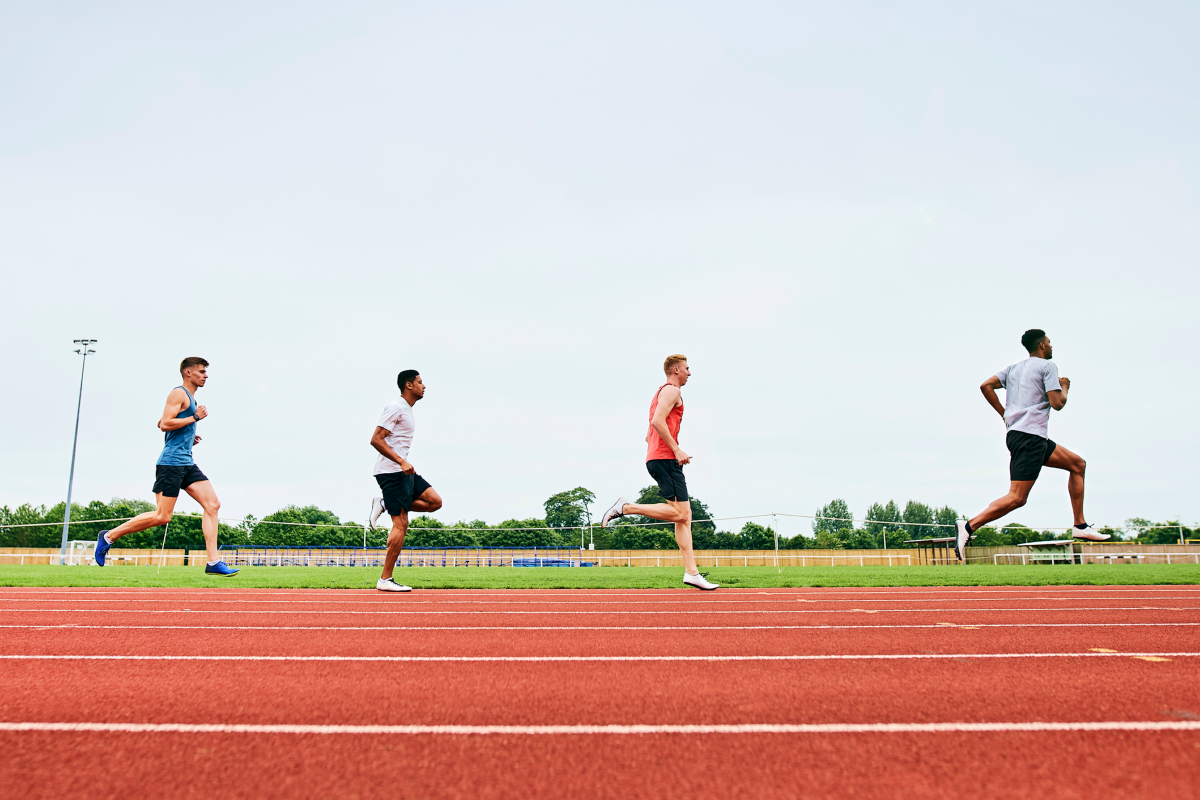 Mężczyźni w odzieży sportowej trenujący bieganie po bieżni