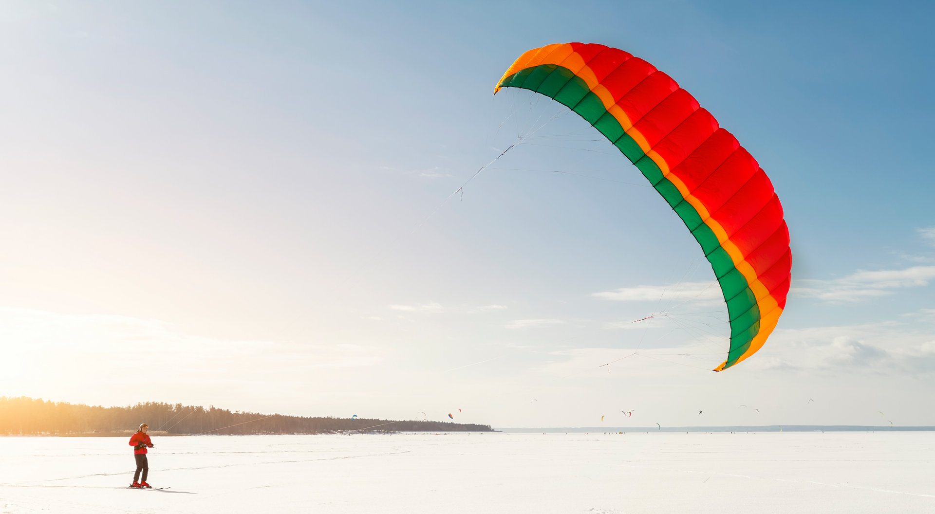 Mężczyzna uprawiający kitesurfing z latawcem na śniegu