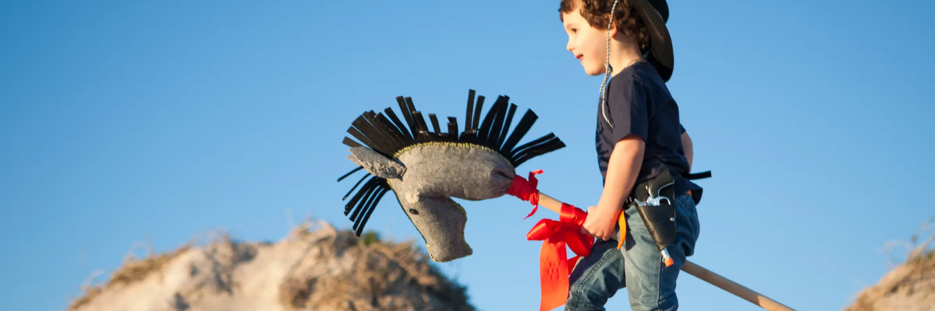 Chłopiec przebrany za kowboja trzymający w ręku hobby horse