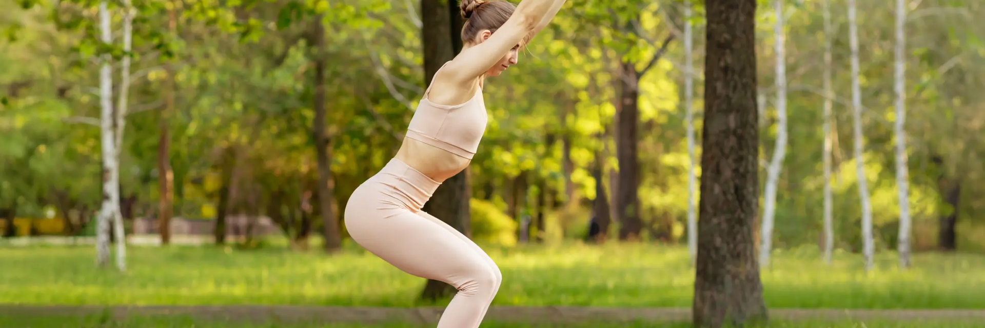 Kobieta w odzieży sportowej ćwicząca na macie pozycję utkatasana w jodze w parku