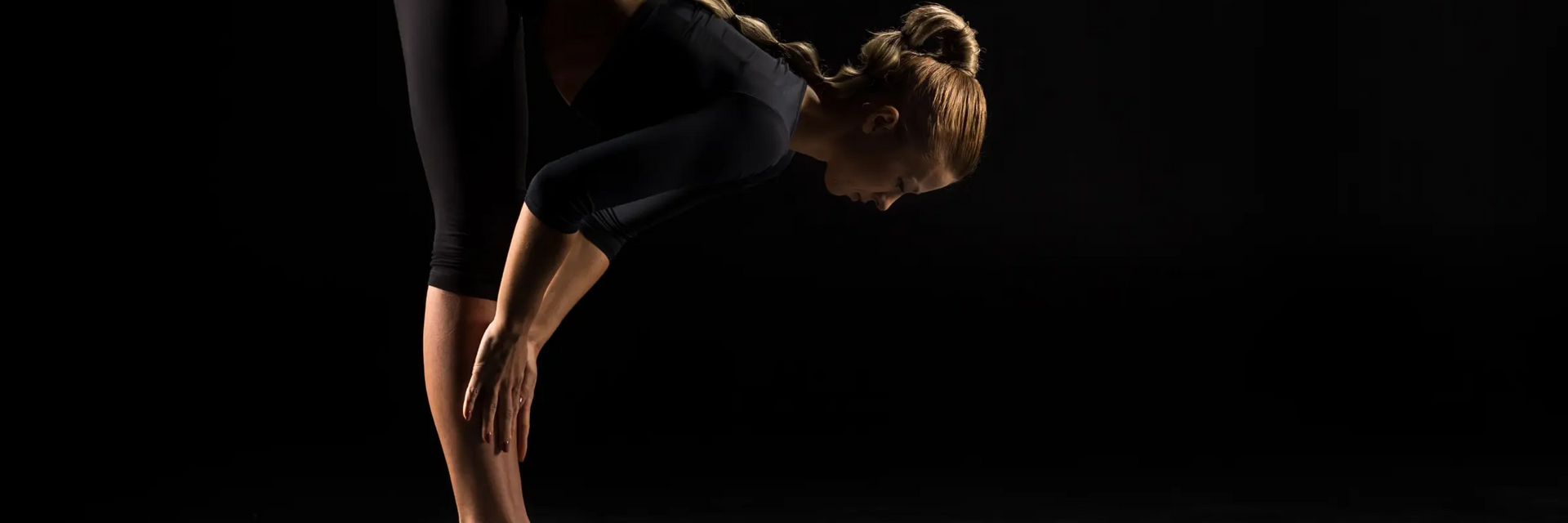 Kobieta ćwicząca na macie pozycję ardha uttanasana w jodze