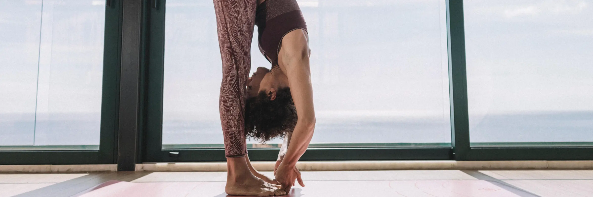 Kobieta ćwicząca asanę padangusthasana na macie