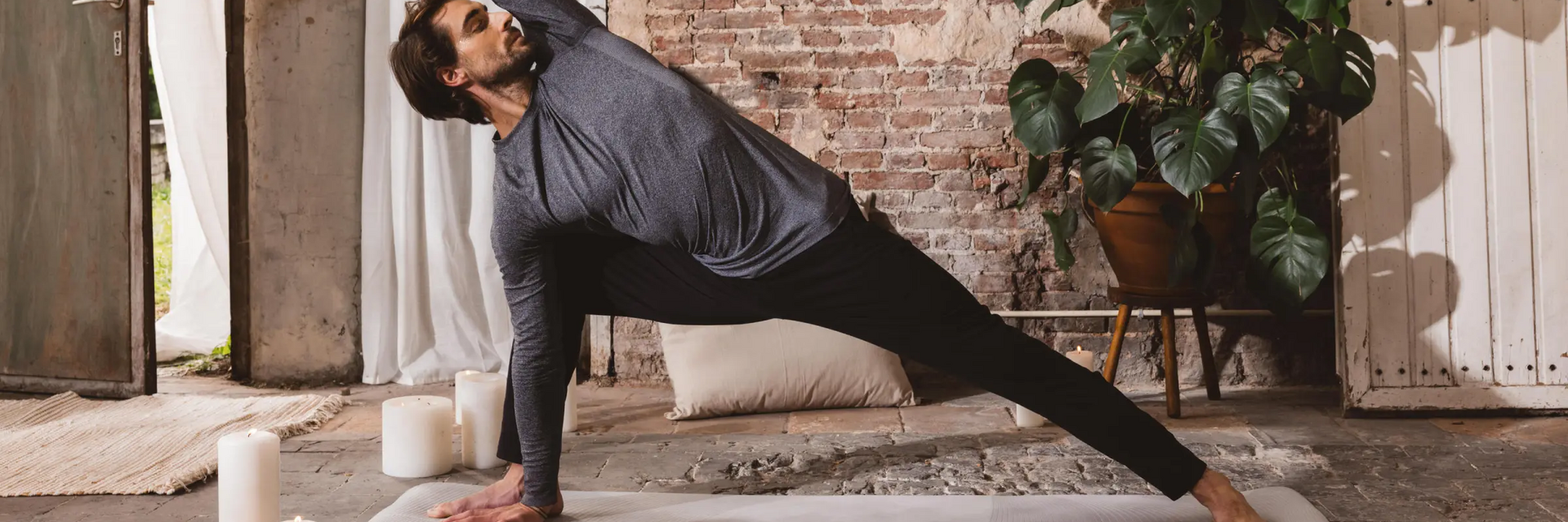 Mężczyzna w odzieży sportowej ćwiczący na macie pozycję utthita parsvakonasana w jodze