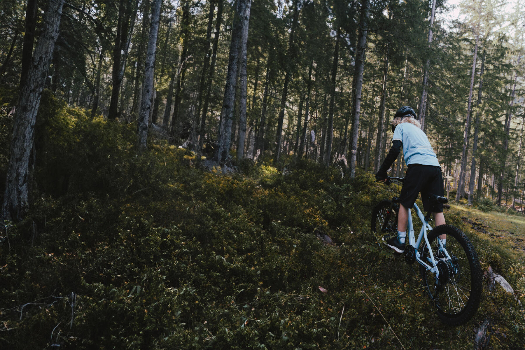 Chłopak jeżdzący rowerem mtb po lesie