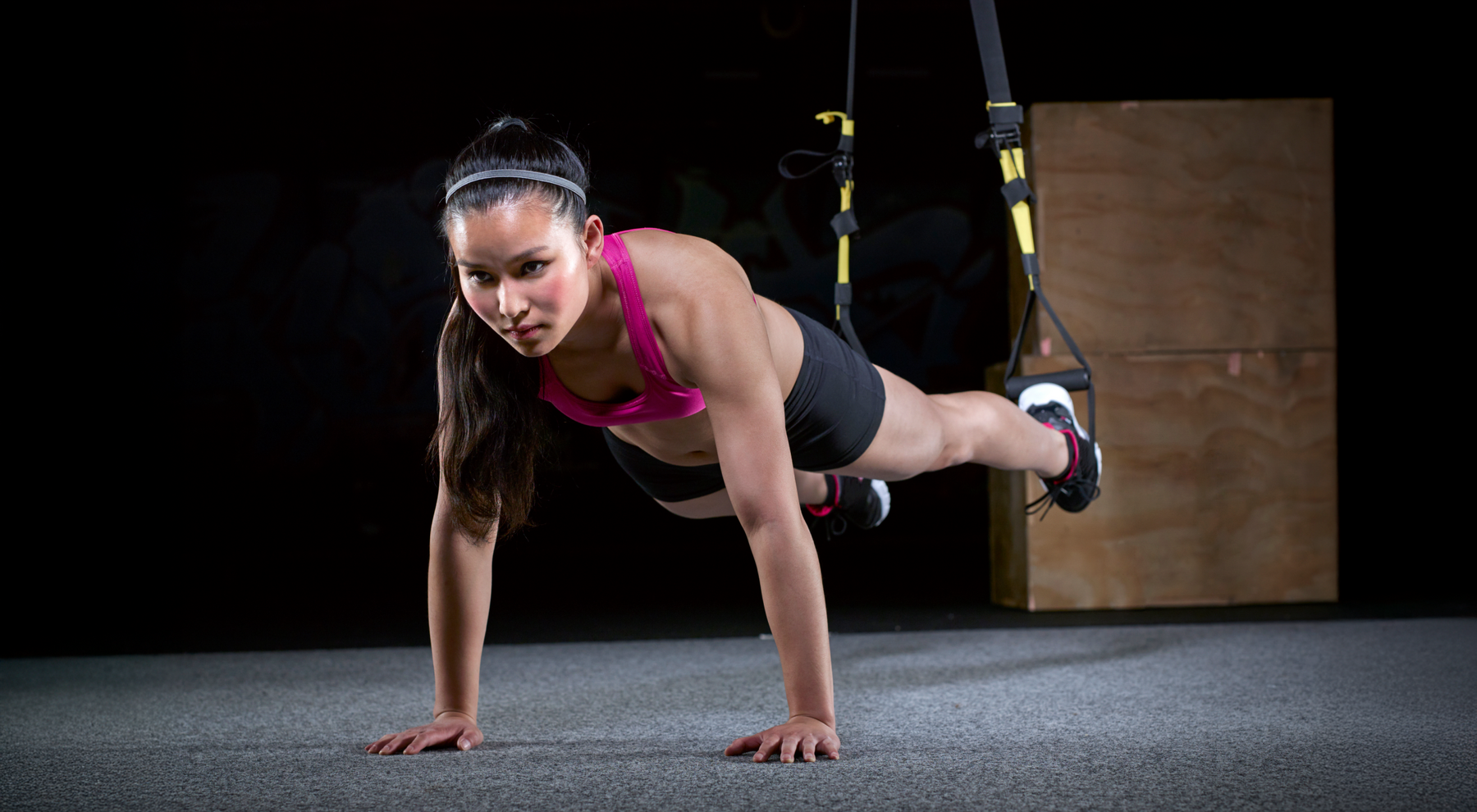 Kobieta w odzieży sportowej ćwicząca trx plank