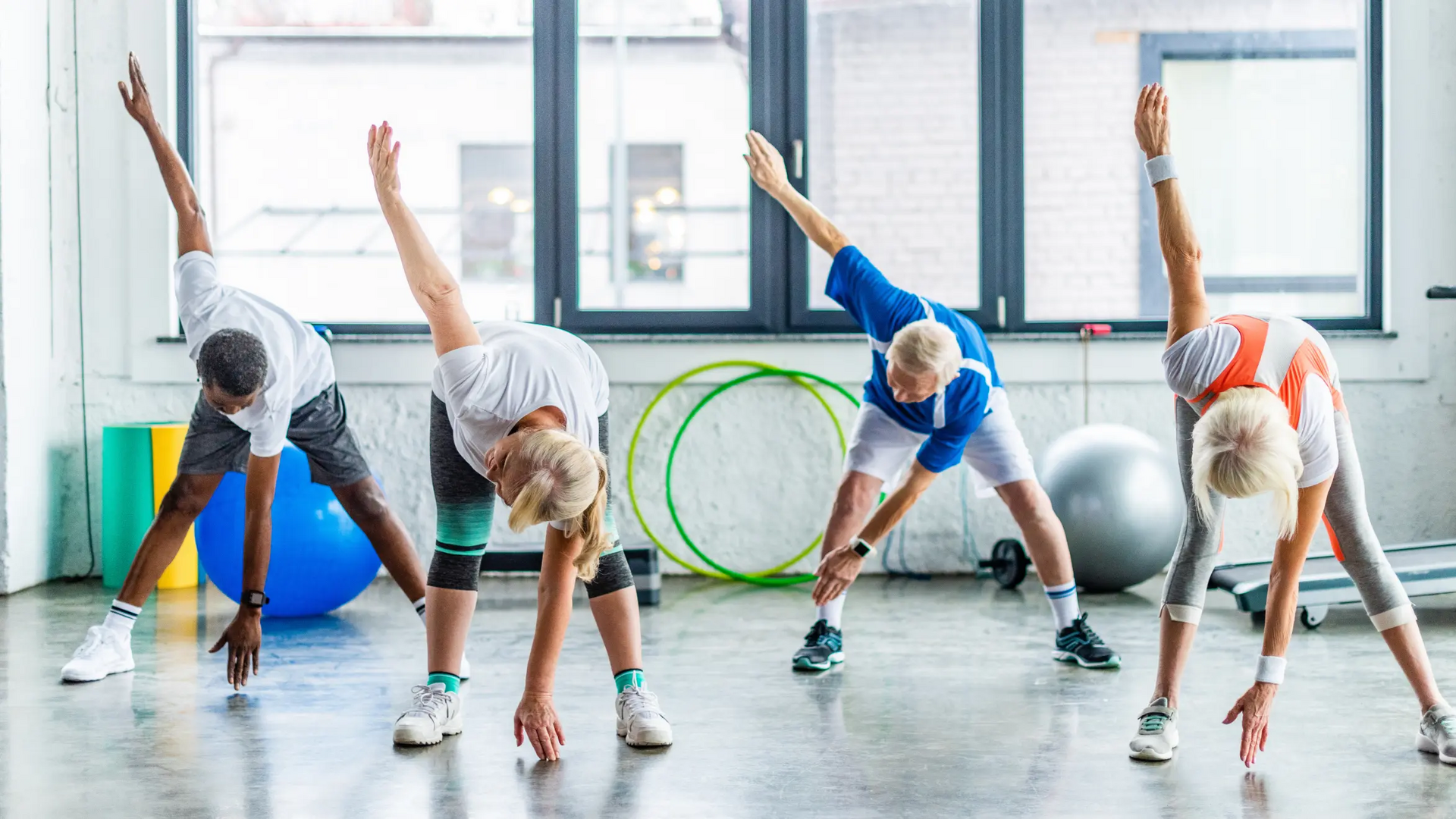 Ludzie ćwiczący skrętoskłony na zajęciach fitness