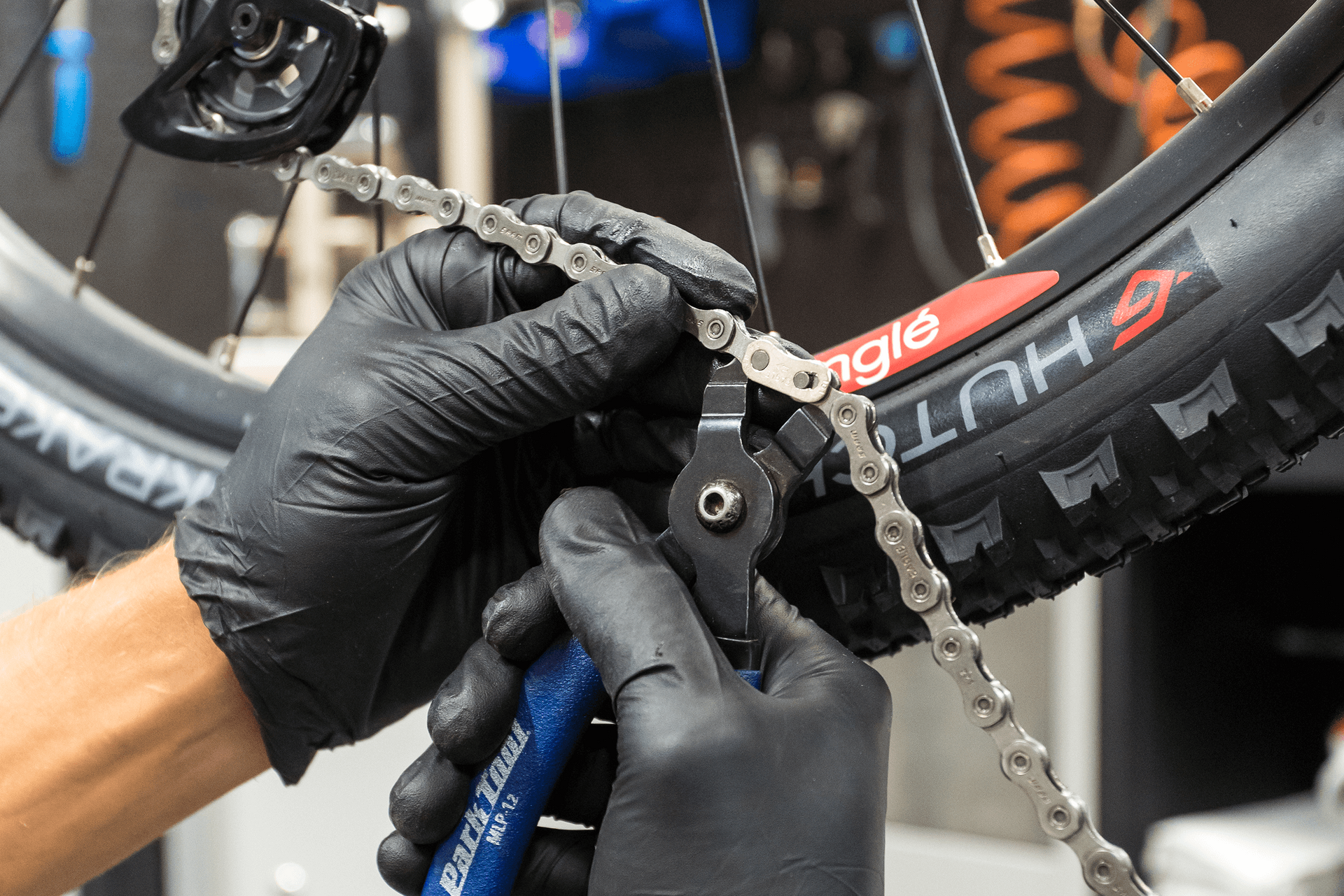 Man undoing a bike chain with chain break tool