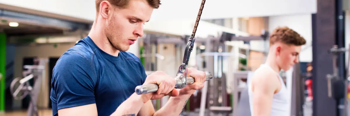 Mężczyzna ćwiczący triceps na wyciągu