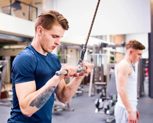 Mężczyzna ćwiczący triceps na wyciągu