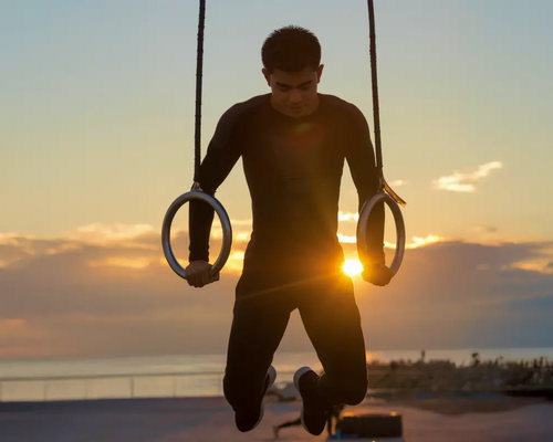 Mężczyzna ćwiczący ring dips na dworze