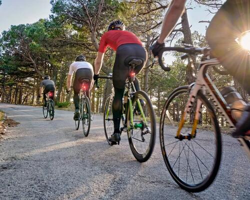 Ludzie w kaskach jadący rowerami na wycieczkę rowerową