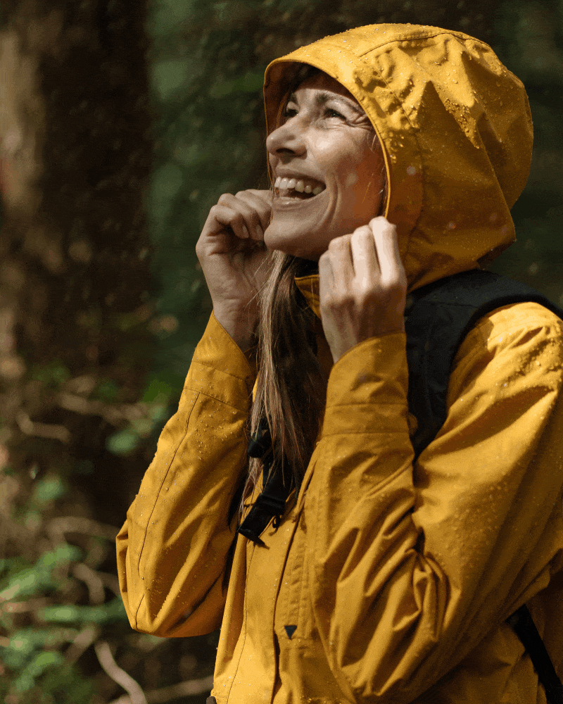 Frau, Mann und Kinder stehen im Regen und freuen sich