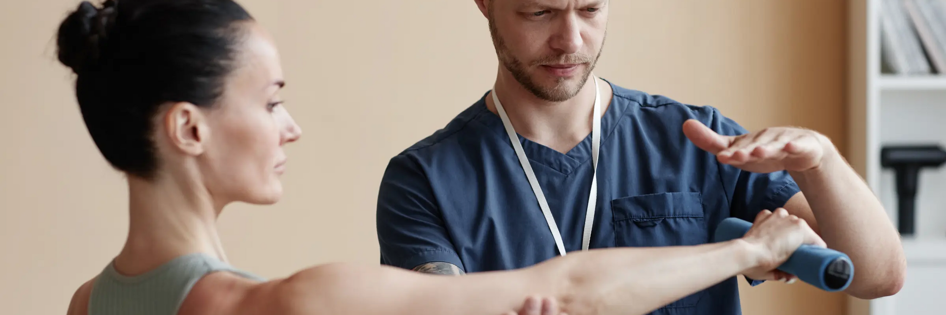 Fizjoterapeuta sprawdzający staw łokciowy kobiecie poprzez wykonanie testu thomsona