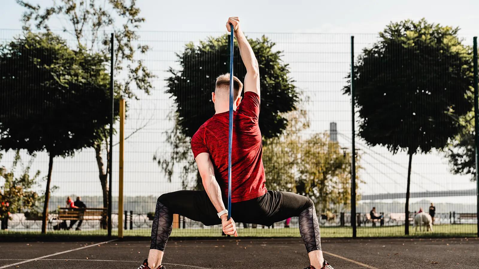 Mężczyzna w odzieży sportowej ćwiczący hip hinge na boisku