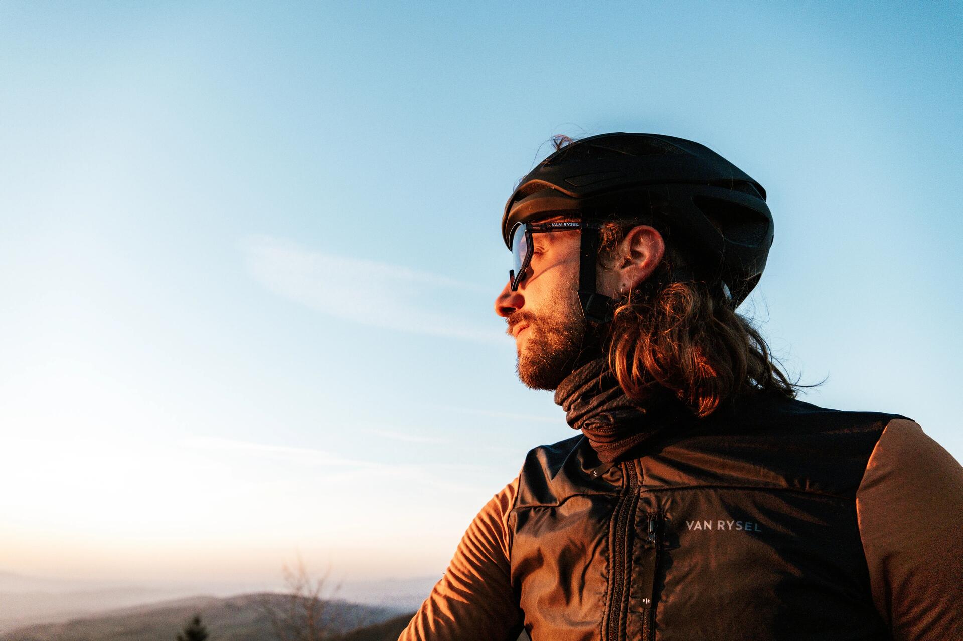 Man cycling in greenery, wearing a black cycling cap.