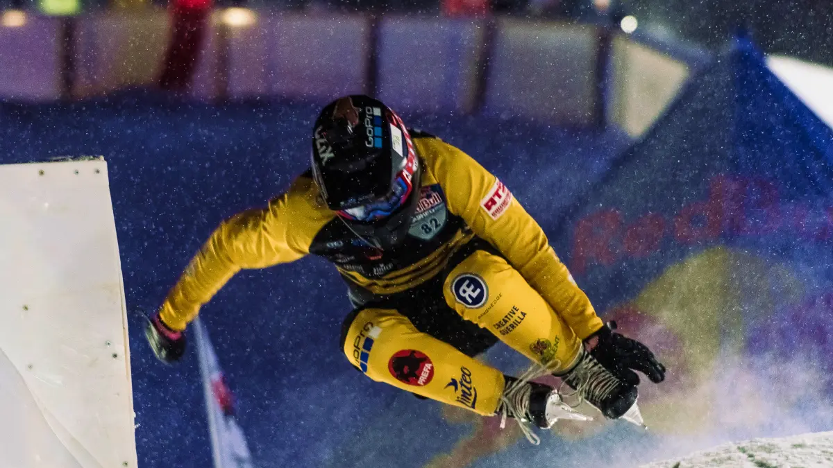 Zawodnik ice cross downhill skaczący na łyżwach