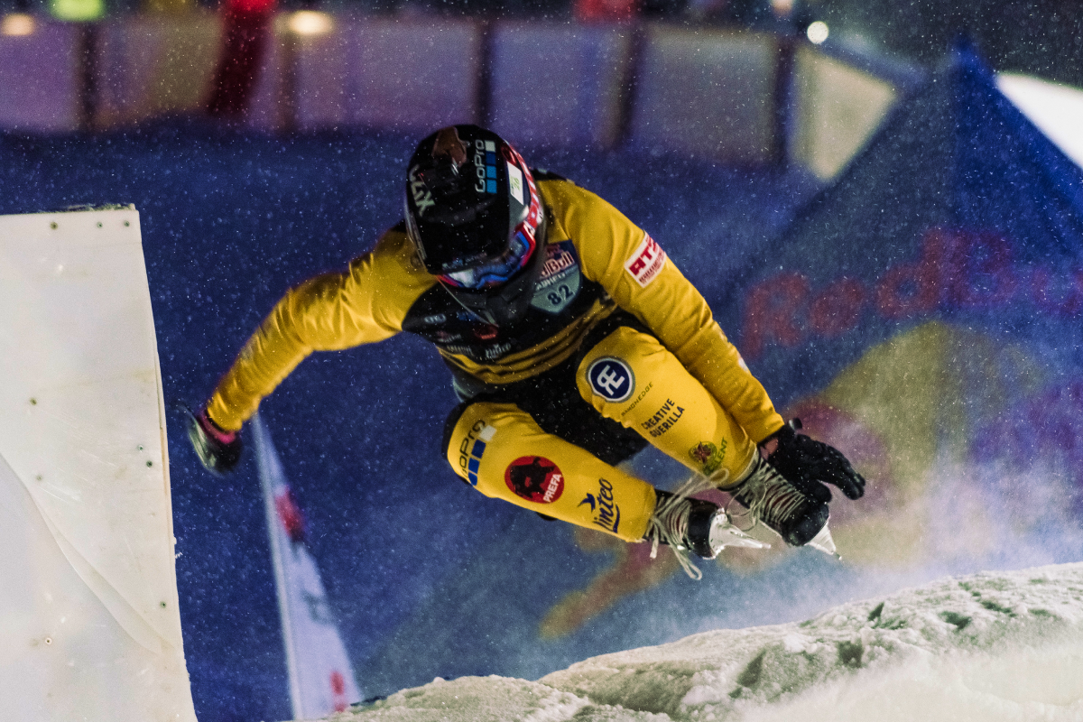 Zawodnik ice cross downhill skaczący na łyżwach
