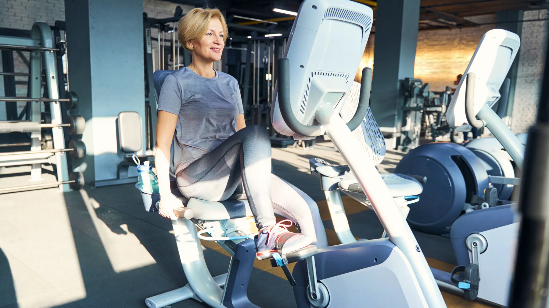 Kobieta w odzieży sportowej ćwicząca na rowerze poziomym