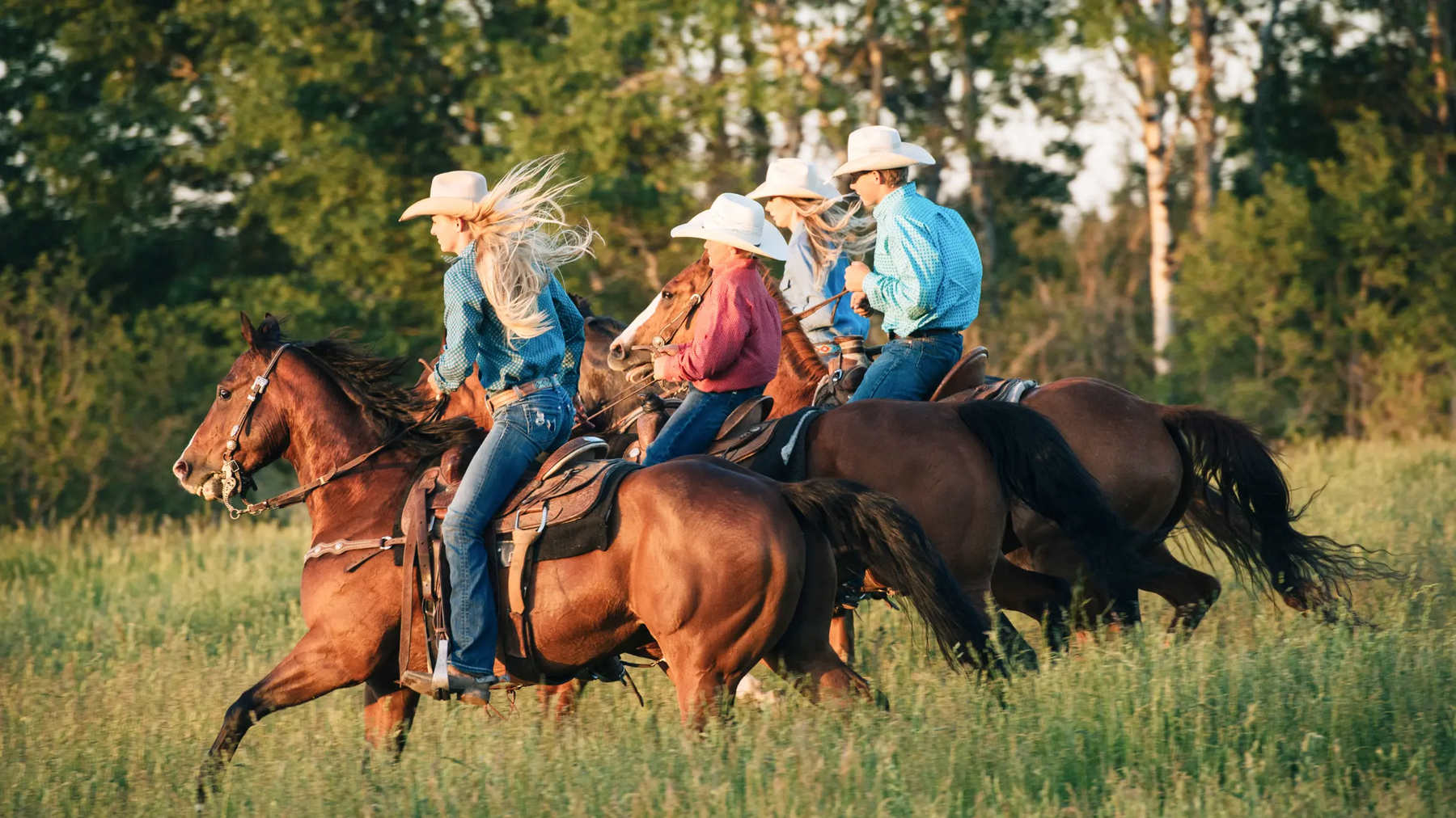 Ludzie w kapeluszach jadący na koniach w stylu western riding
