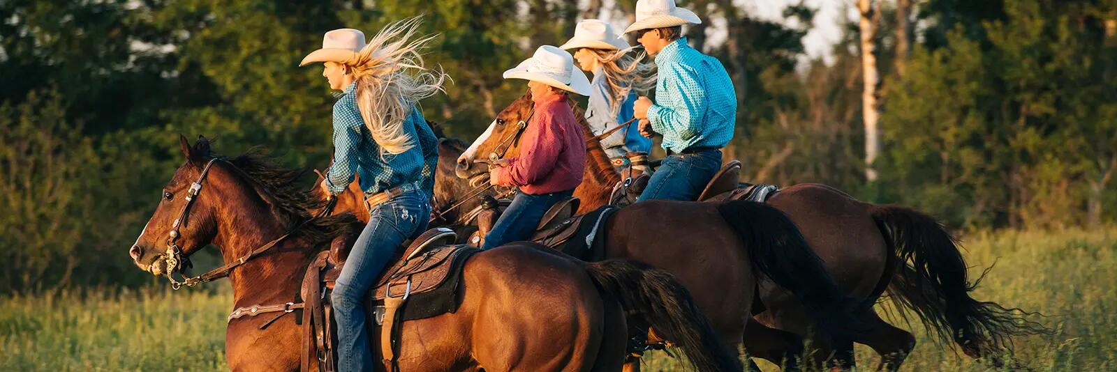 Ludzie w kapeluszach jadący na koniach w stylu western riding