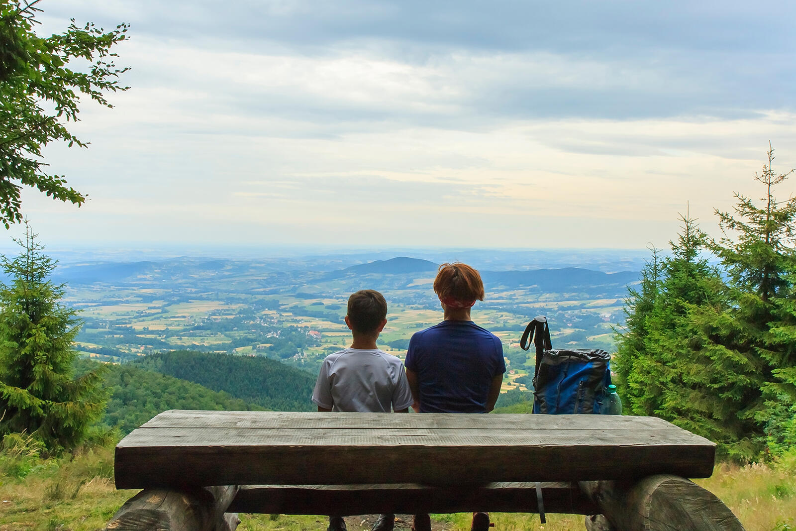 Ludzie siedzący na ławce podziwiający widok na Beskid Wyspowy