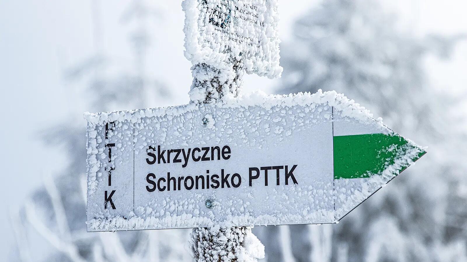 Znak w górach przysypany śniegiem