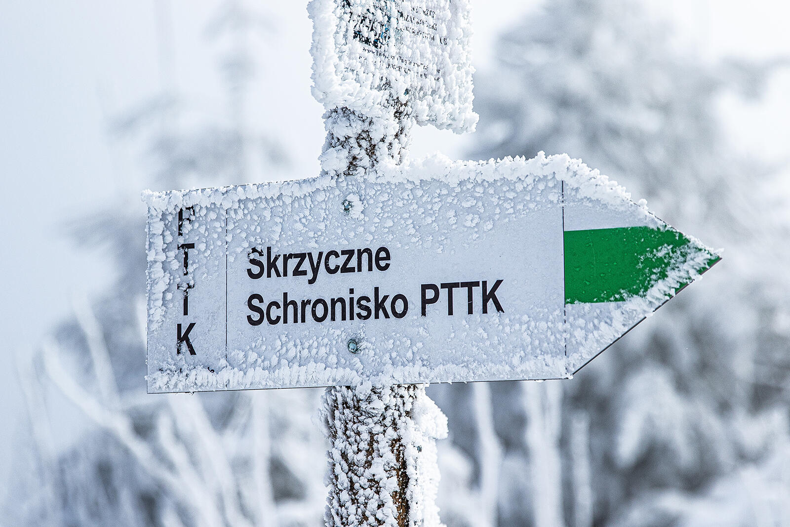 Znak w górach przysypany śniegiem