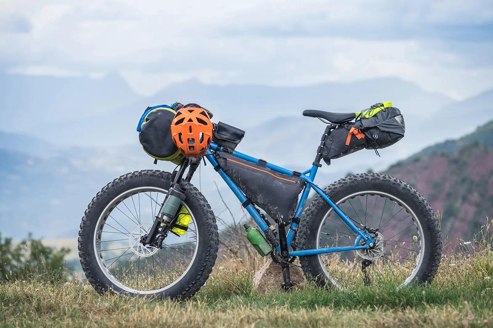 Fatbike stojący na trawie z kaskami na kierownicy