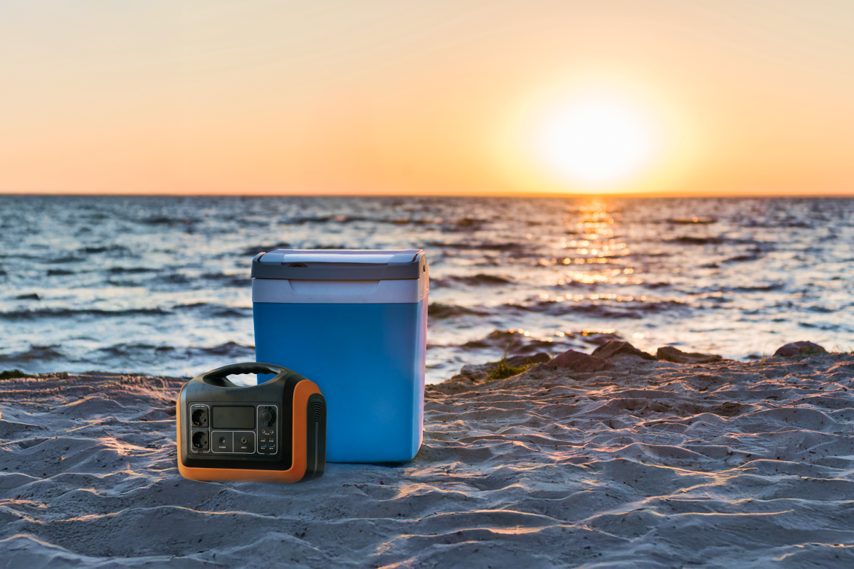 Akumulator stojący obok lodówki turystycznej na plaży