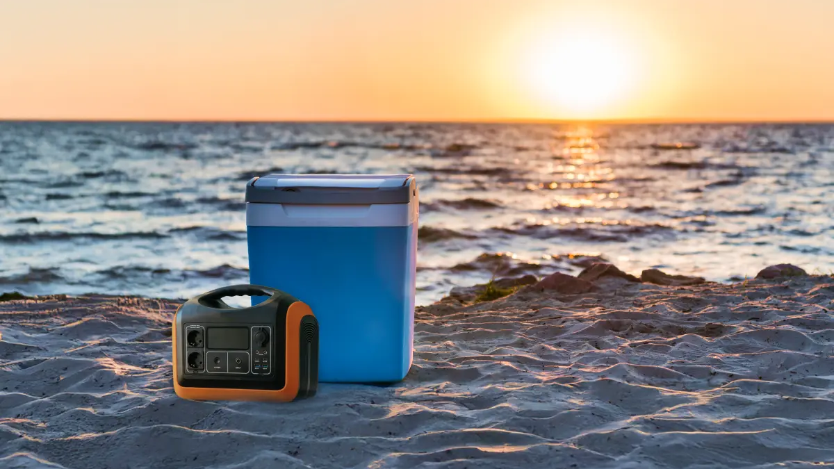 Akumulator stojący obok lodówki turystycznej na plaży