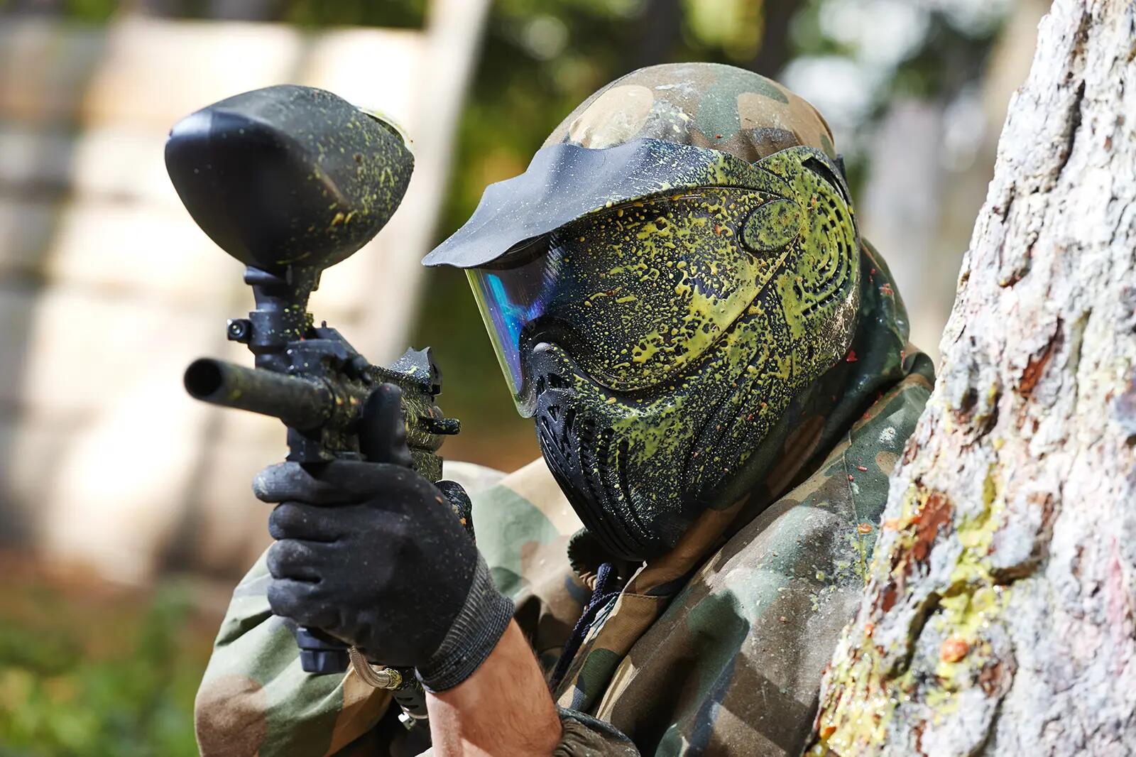 Osoba w kasku grająca w paintball