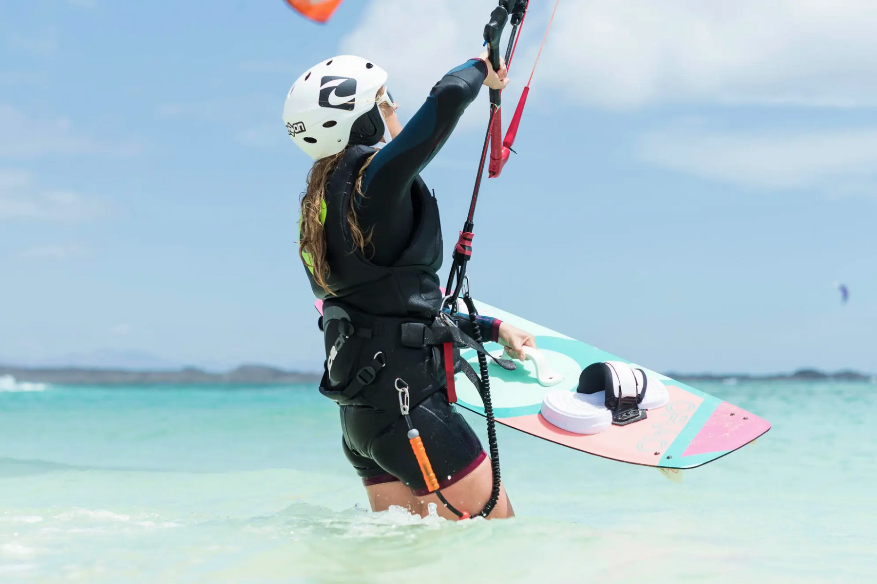 Kobieta trzymająca deskę do kitesurfingu w wodzie