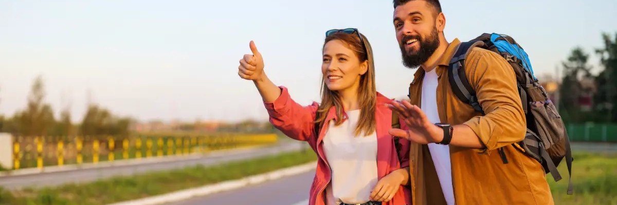 Para z plecakami łapiąca stopa
