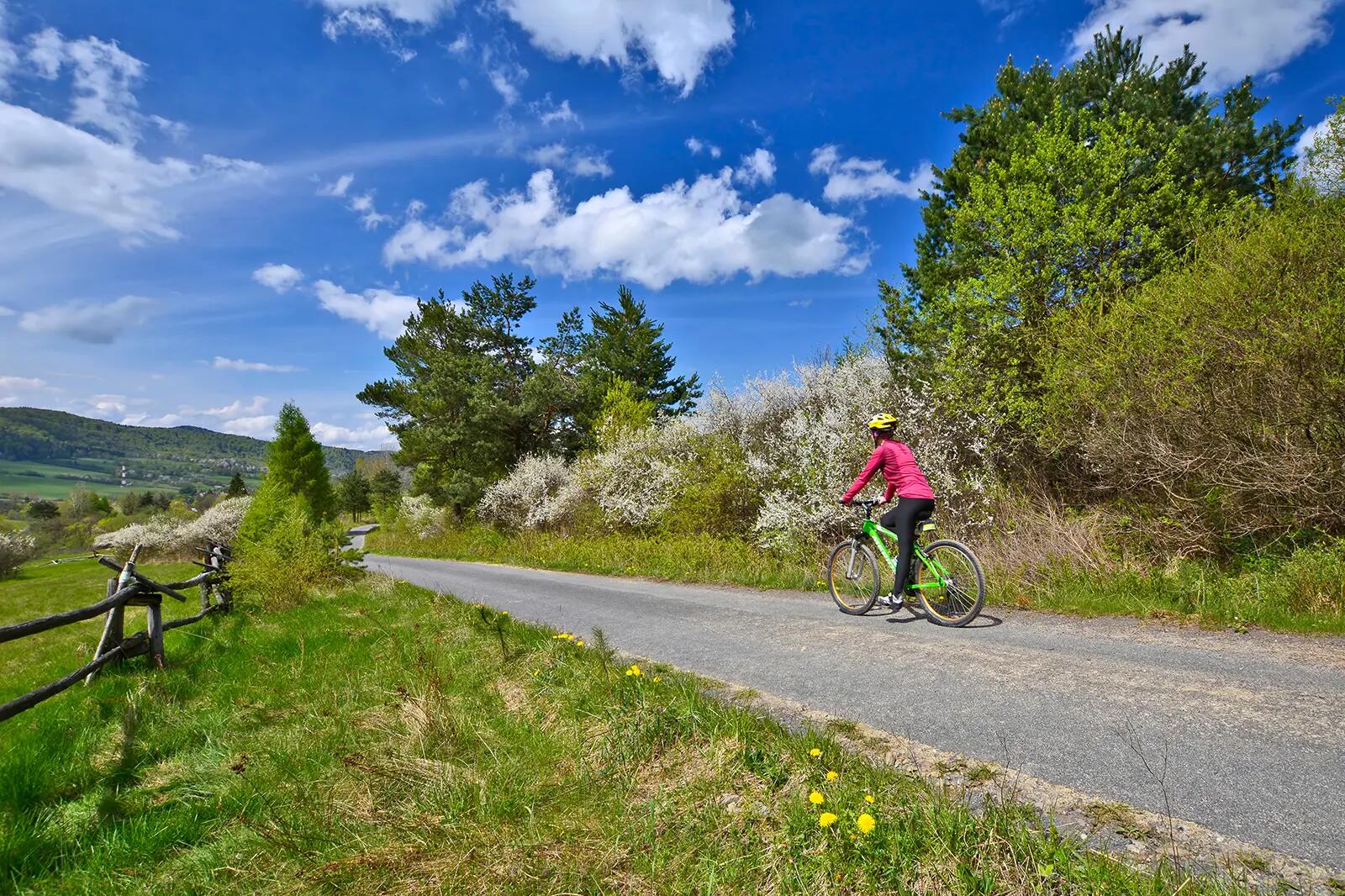 Kobieta w kasku zwiedzająca Beskid Niski na rowerze