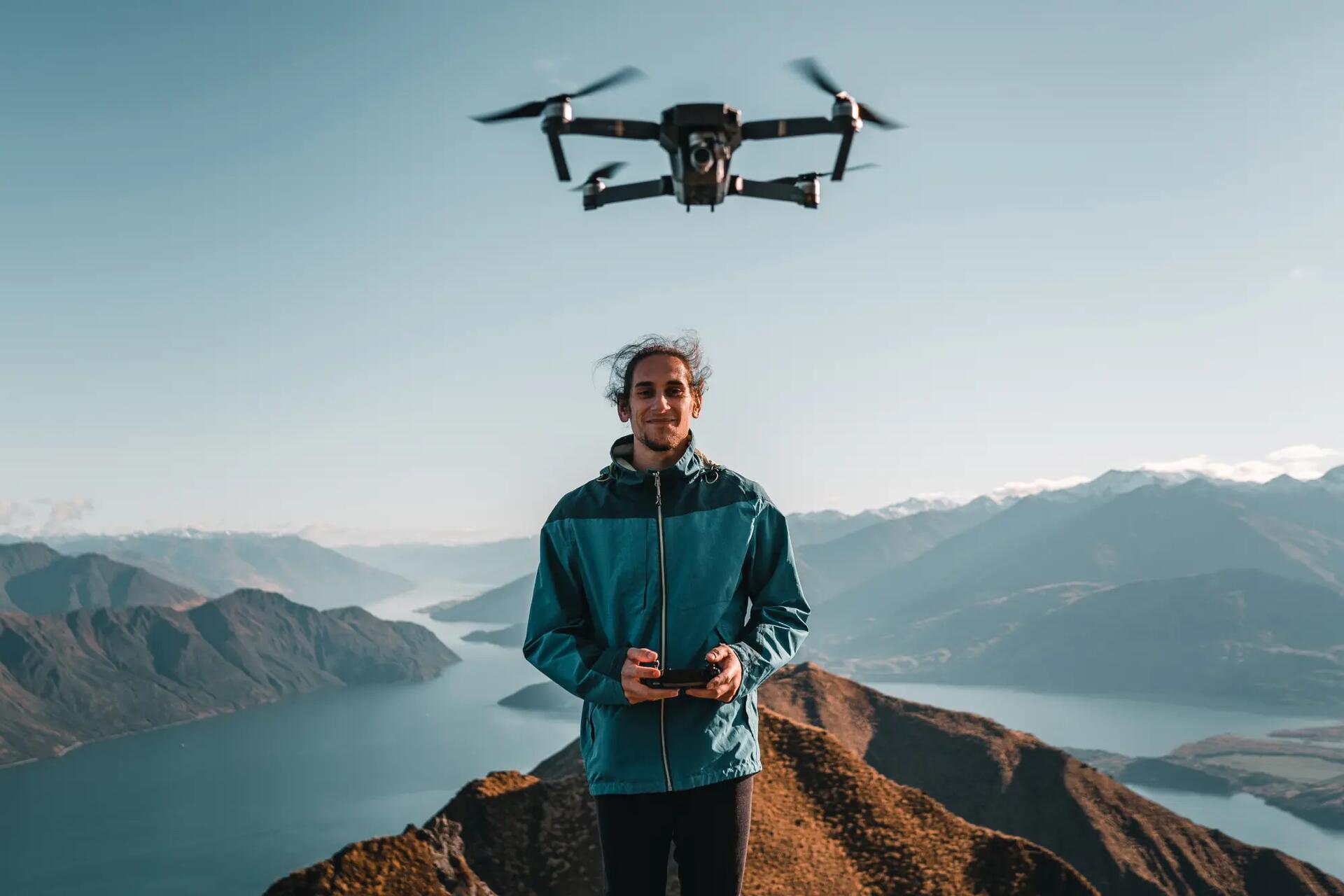 Mężczyzna latający dronem na szczycie góry