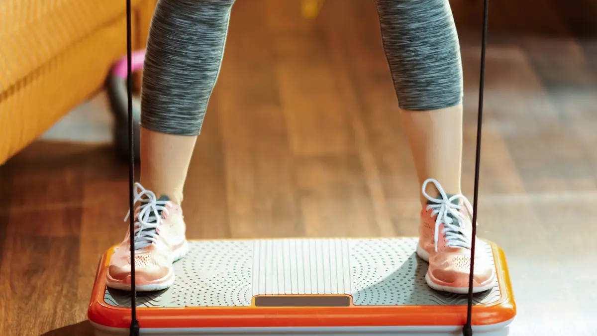 Kobieta w adidasach stojąca na platformie wibracyjnej
