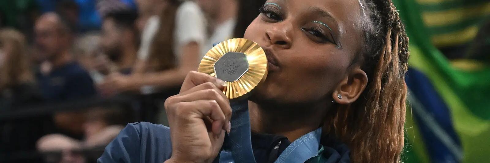 Kobieta całująca złoty medal olimpijski pozująca do zdjęcia