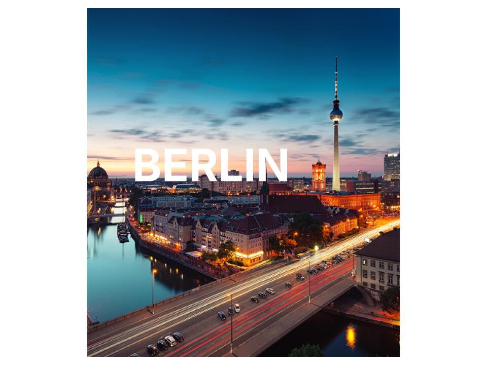 Berlin von oben mit einem weißen Berlin Schriftzug im Vordergrund.