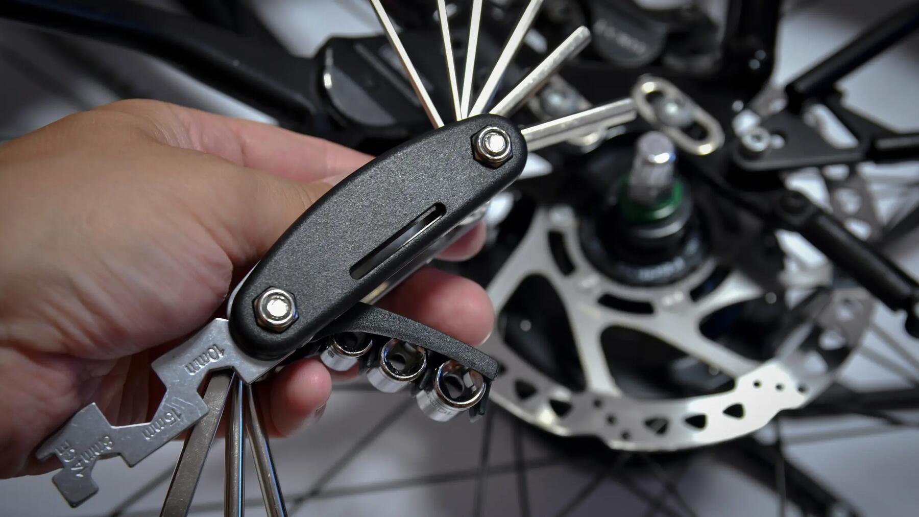 Mężczyzna trzymający w ręku multitool rowerowy