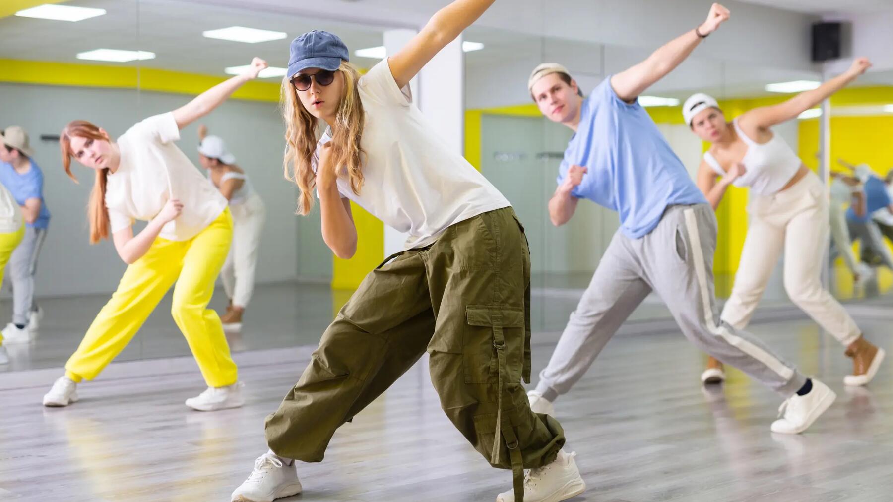 Młodzi ludzie tańczący hip-hop na sali