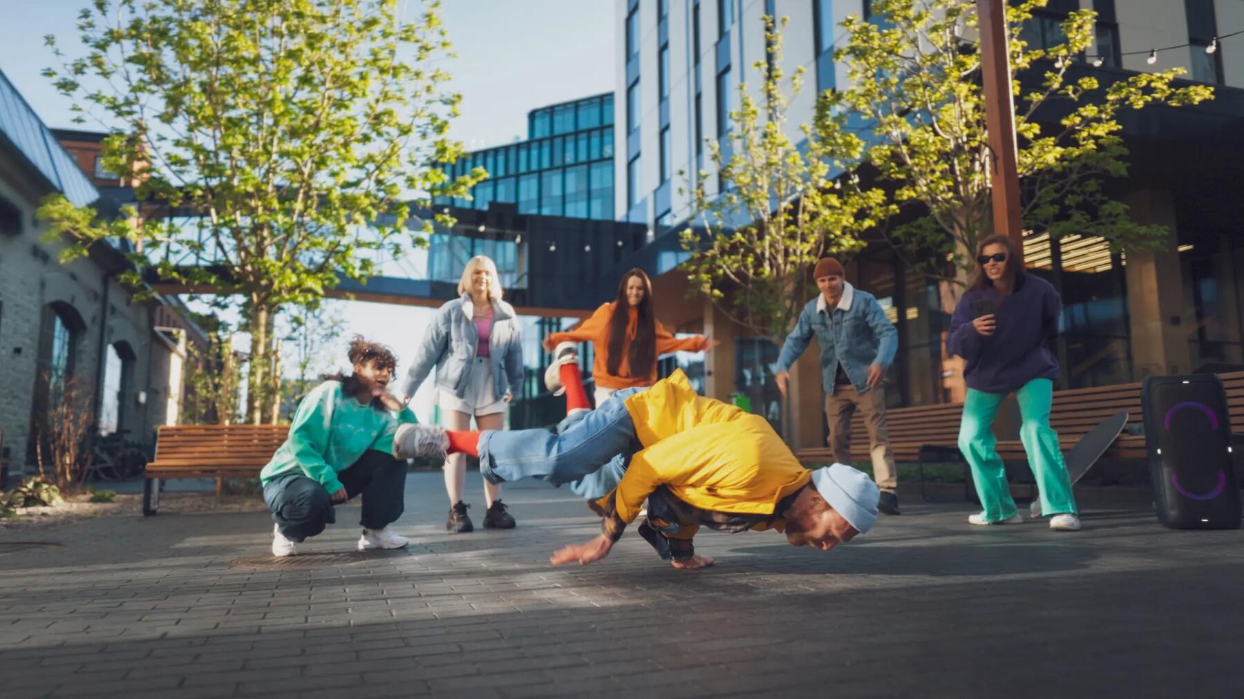 Mężczyzna tańczący breakdance wkoło ludzie